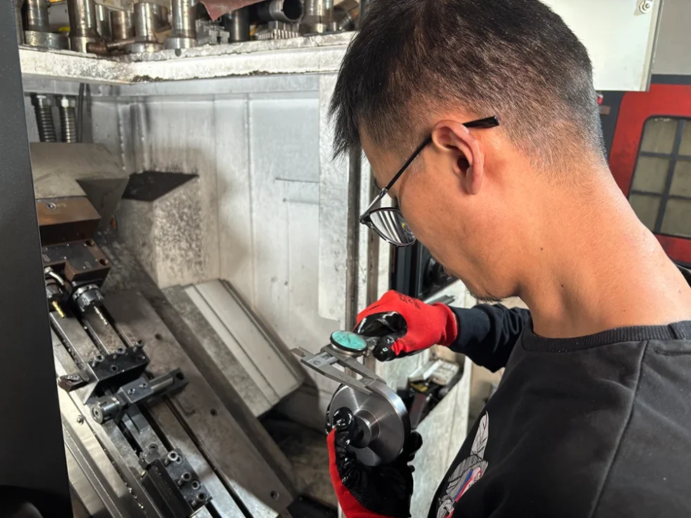 DREJEX founder Jack using a dial caliper to inspect a precision machined component.